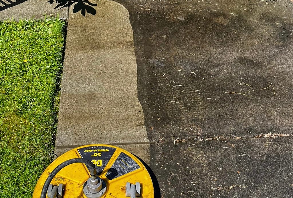 Cleans patio using yellow High-pressure washer.